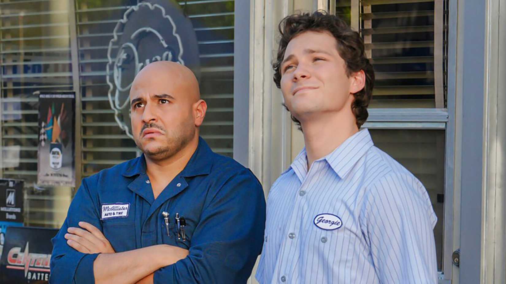 Ruben with his arms folded, Georgie smiling in Georgie & Mandy's First Marriage.