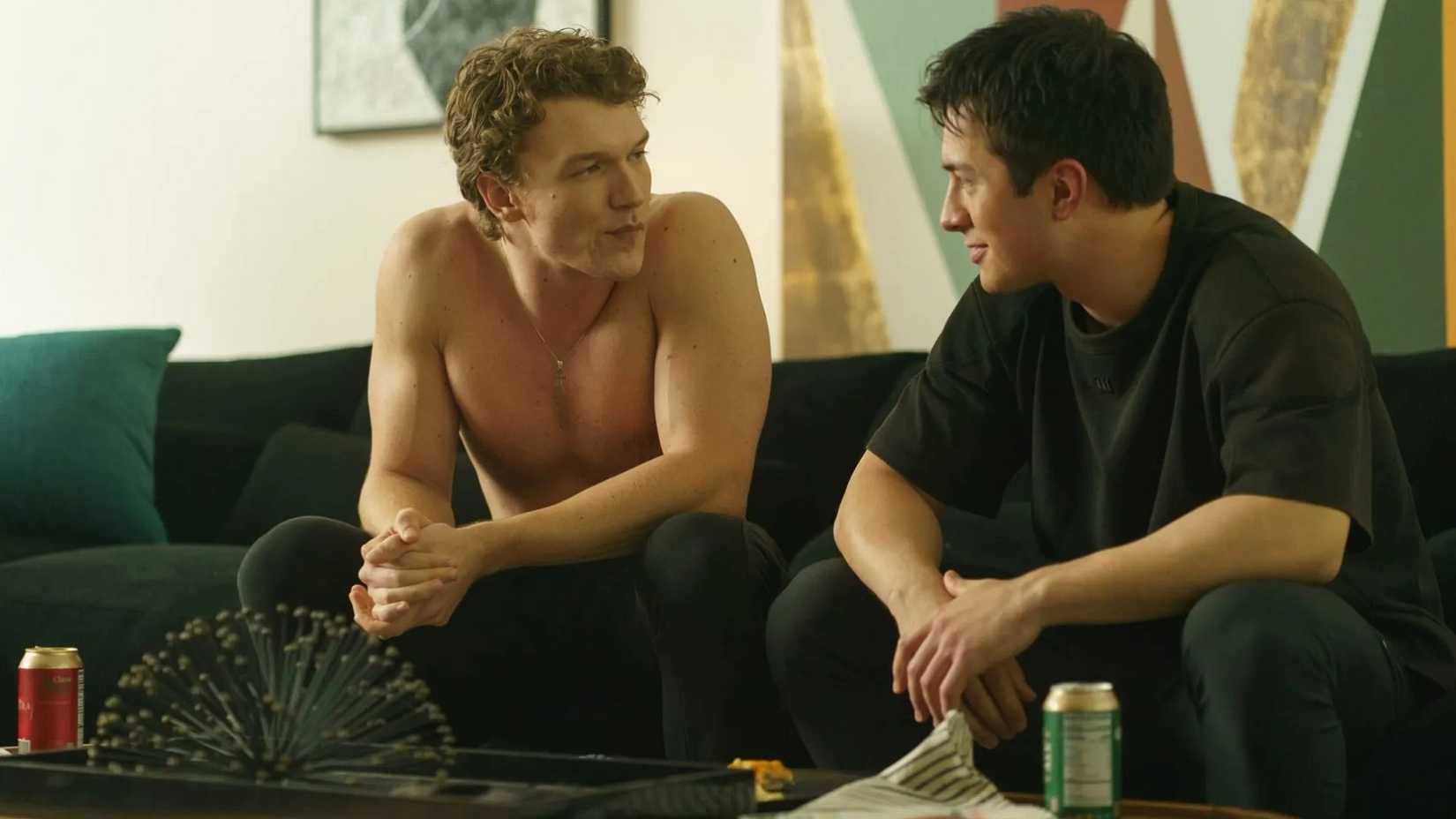 Connor Storrie and Hudson Williams as IIya and Shane on a couch in Heated Rivalry