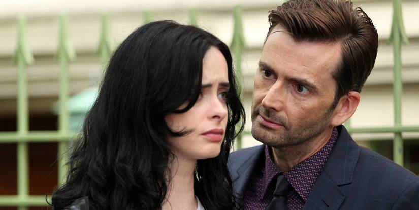 Kilgrave staring at Jessica intently as she stares ahead, looking scared, in Jessica Jones.