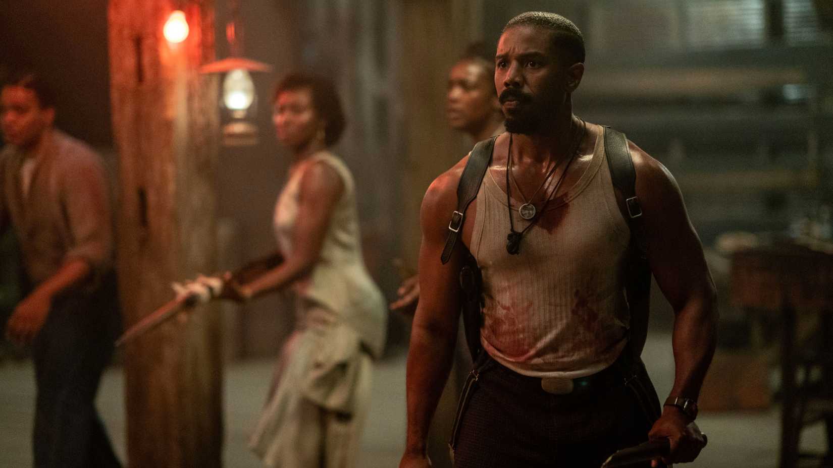 Michael B Jordan di film Sinners mengenakan tank top.