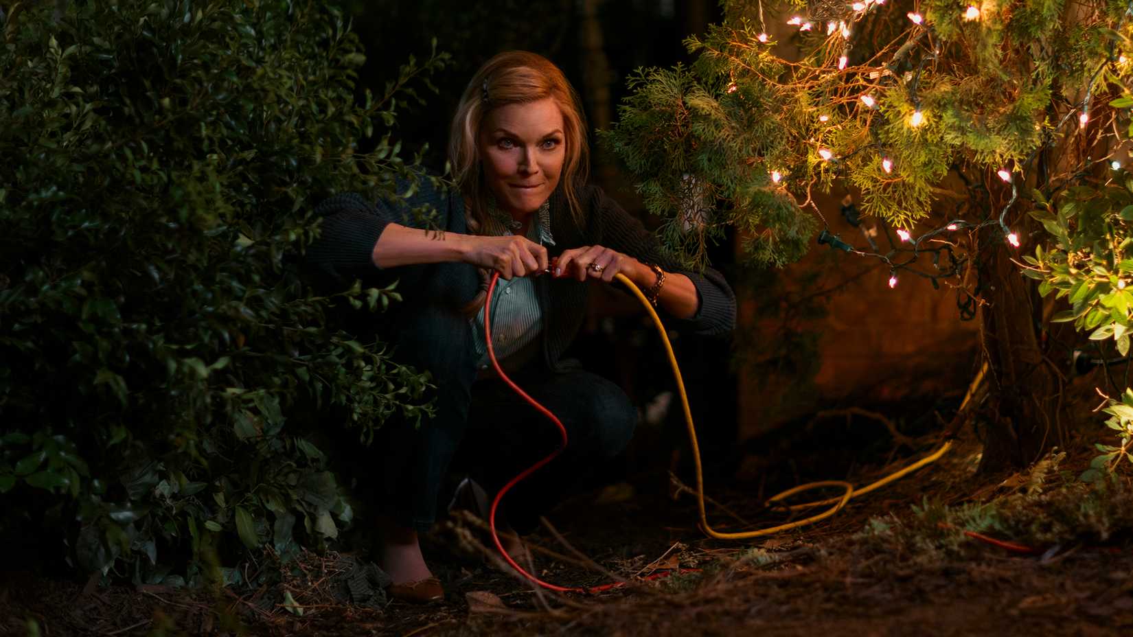 Michelle Pfeiffer connecting an extension cord in 'Oh. What. Fun.'