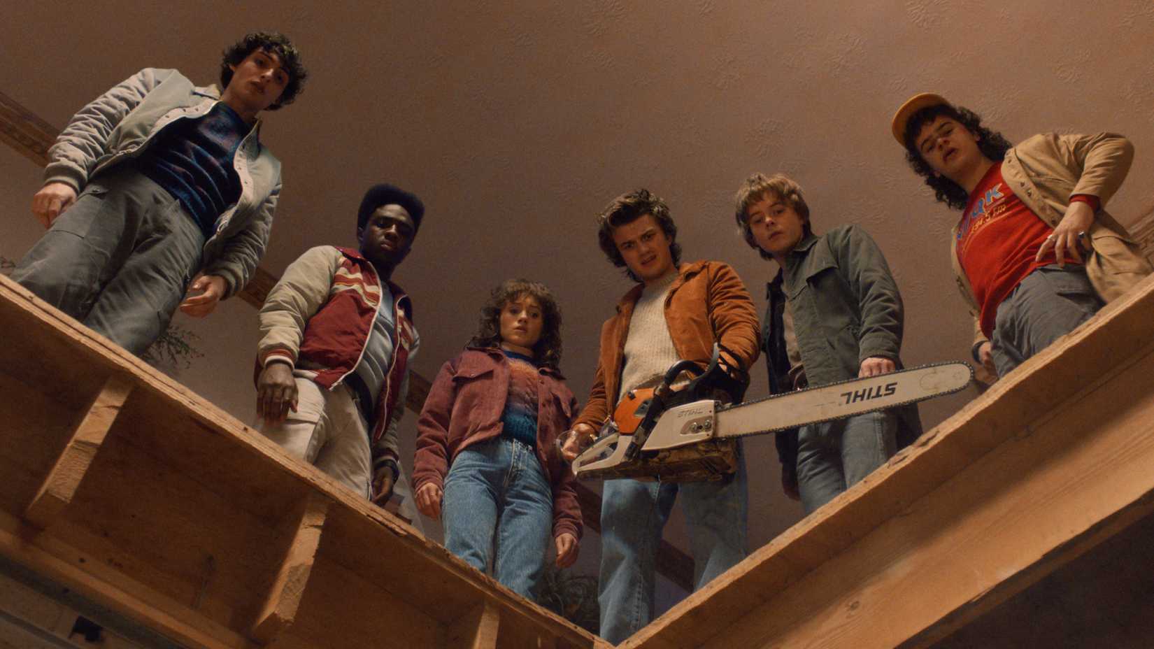 The cast of Stranger Things Season 5 looking down from a second floor
