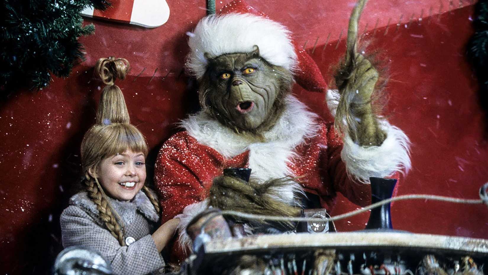 The Grinch riding in his sleigh with a smiling Cindy Lou in How the Grinch Stole Christmas.