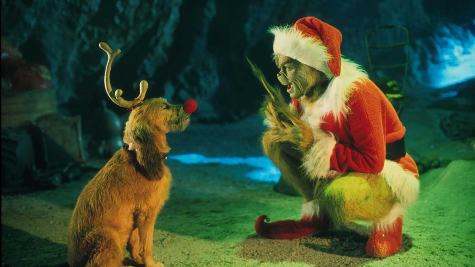 The Grinch crouching down talking to Max the dog in How the Grinch Stole Christmas.