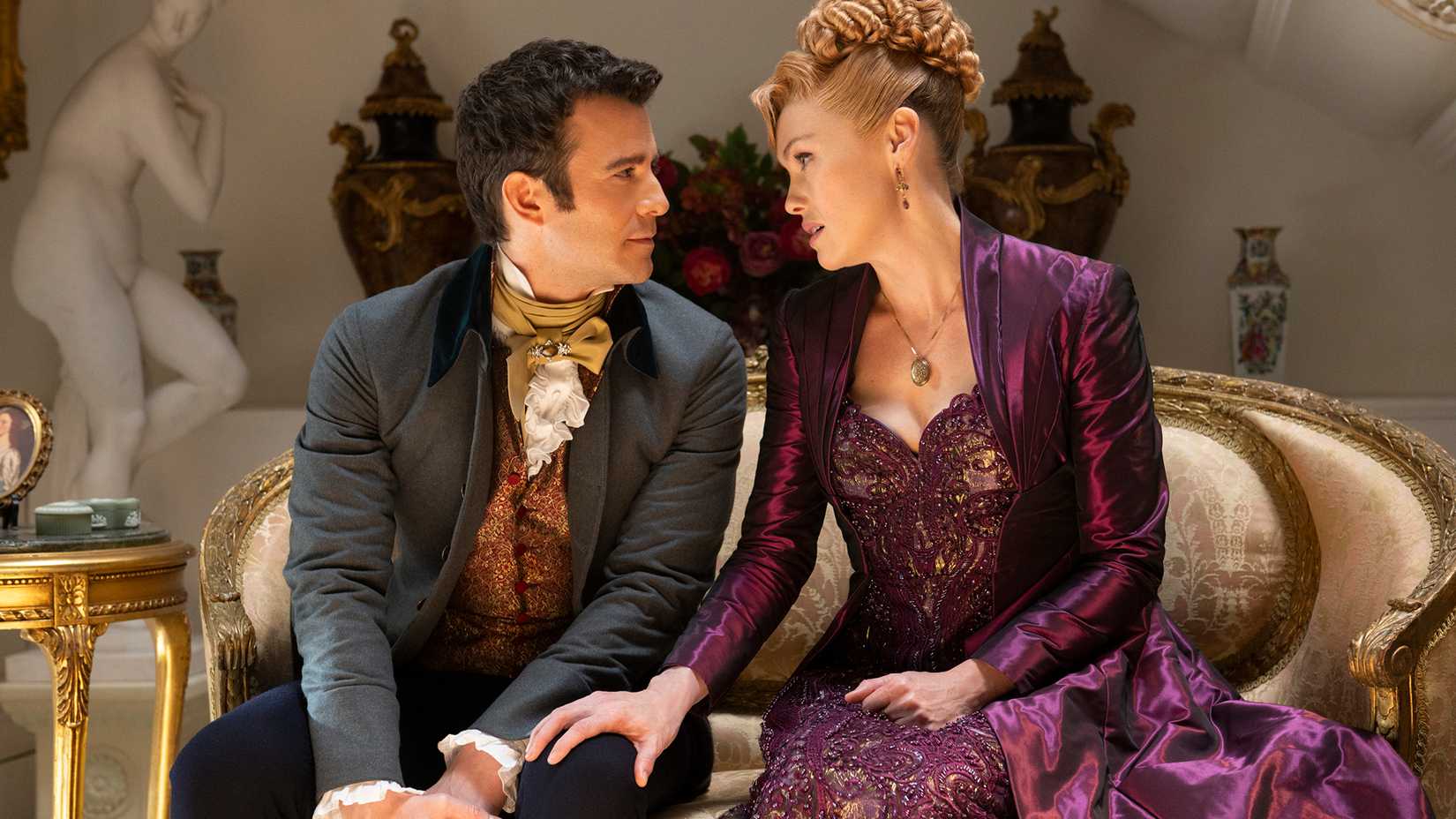 Lady Tilley Arnold putting her hand on Benedict's knee while talking with him in Bridgerton.