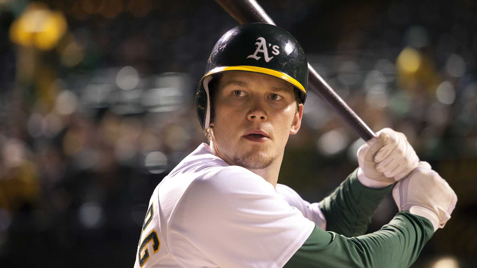 Chris Pratt as Scott Hatteberg, about to swing a baseball bat during a game, in Moneyball.