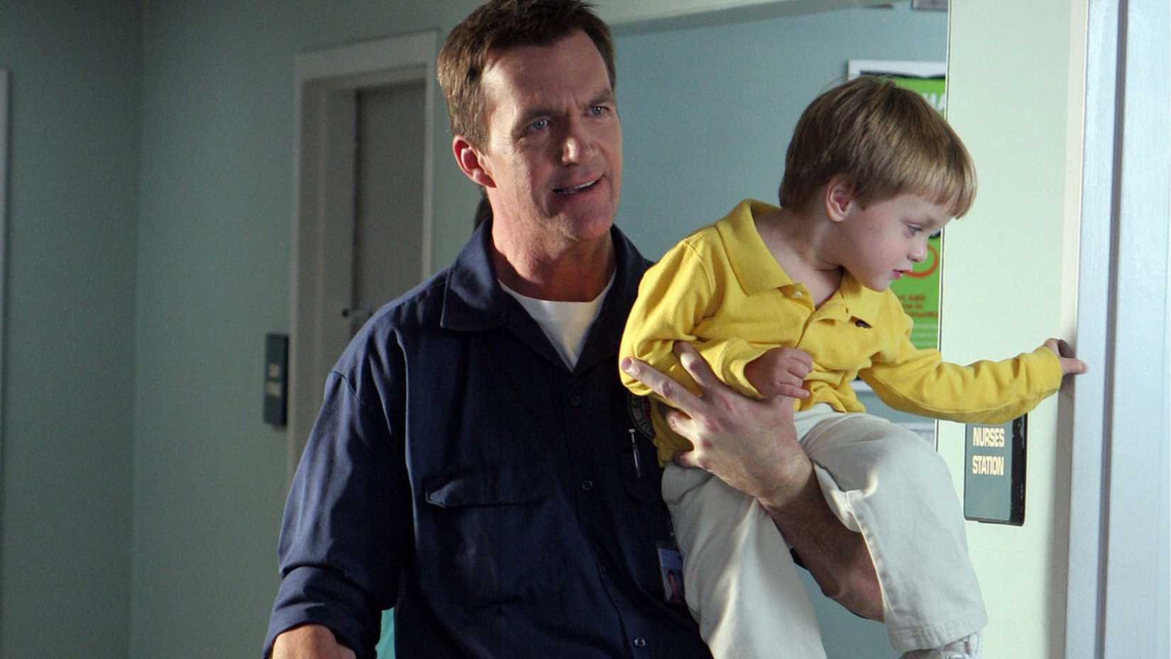 Neil Flynn as the Janitor in Scrubs holding Jack