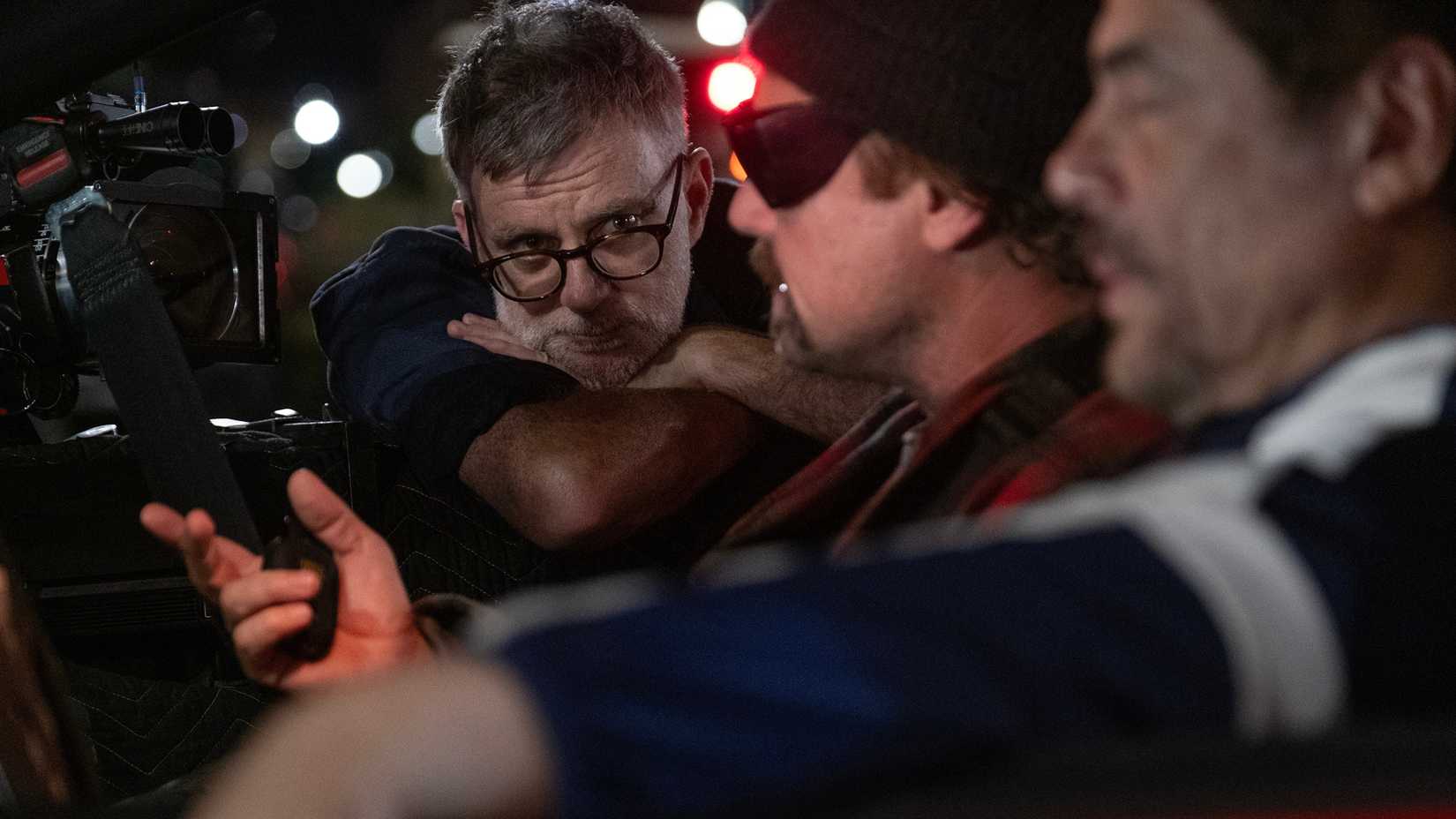 Paul Thomas Anderson directing Leonardo DiCaprio and Benicio del Toro in a car on the set of One Battle After Another.