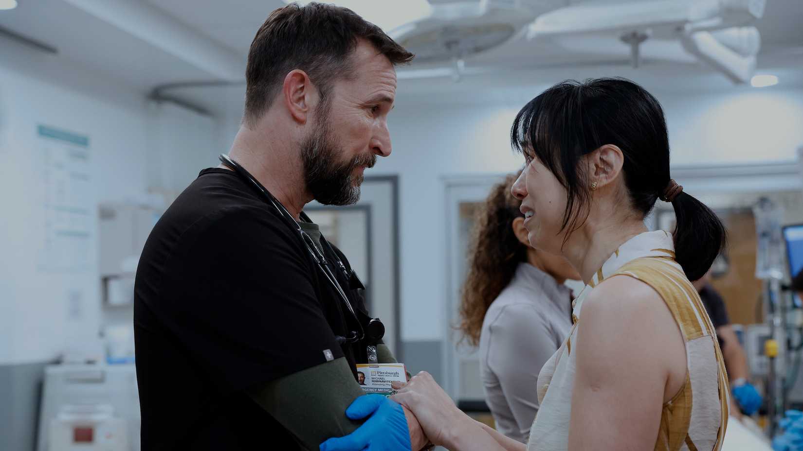 Robby consoling a distraught patient's wife in The Pitt.