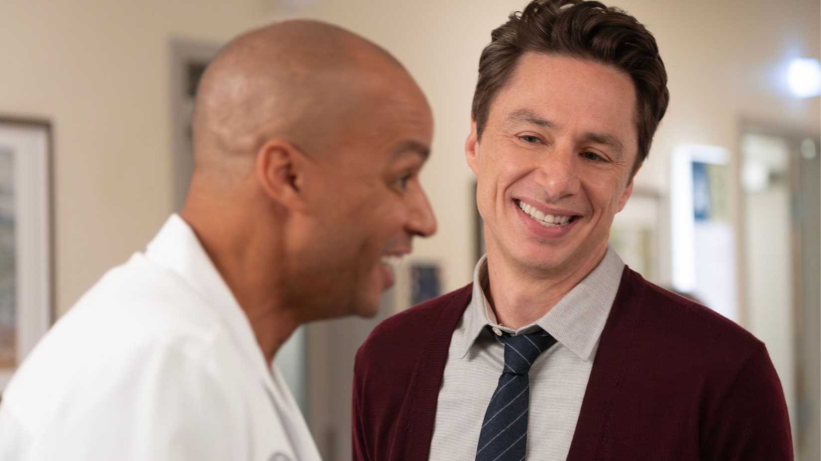 Zach Braff as JD smiling at Donald Faison as Turk in the Scrubs revival
