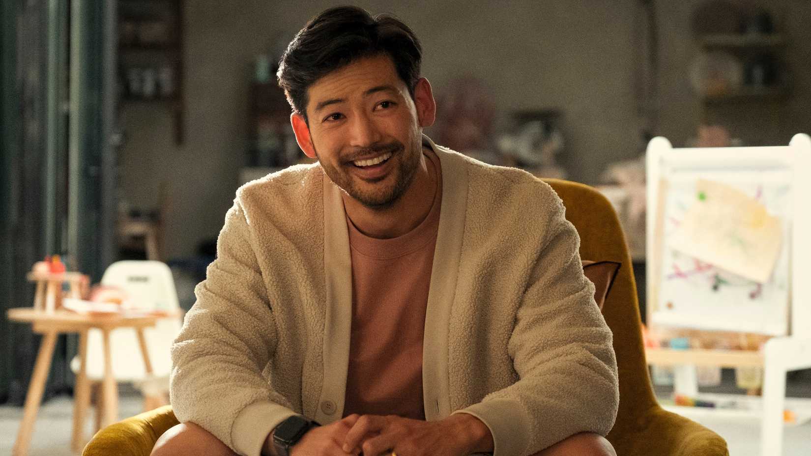 George smiles in a chair in Beef