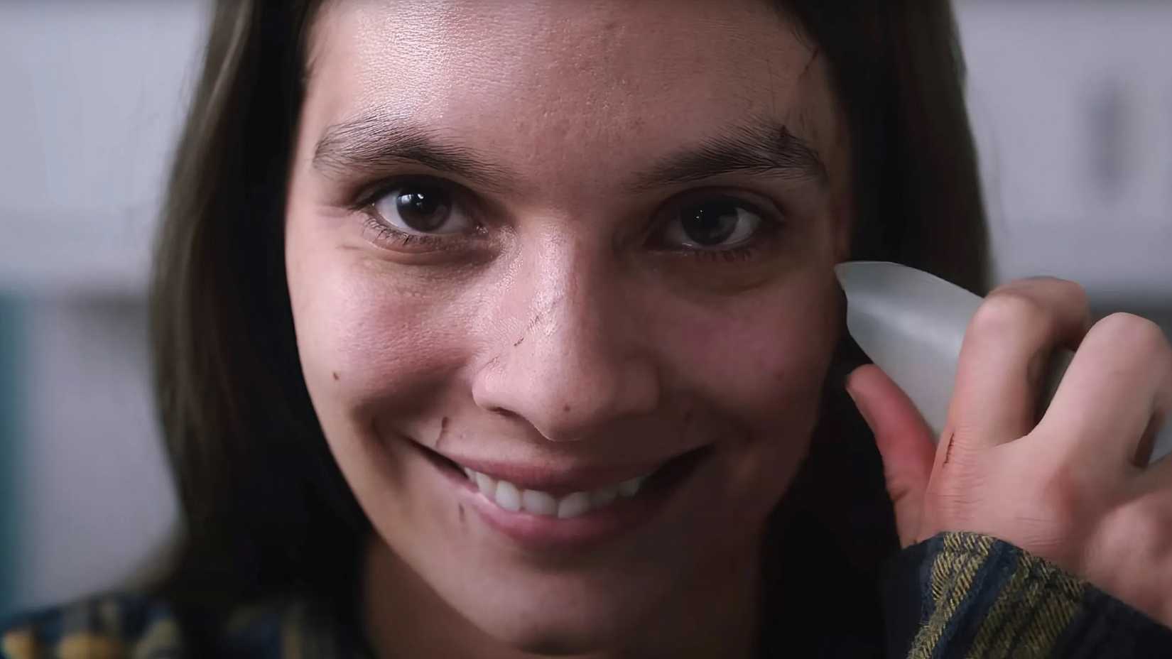 Laura about to cut her face in Smile