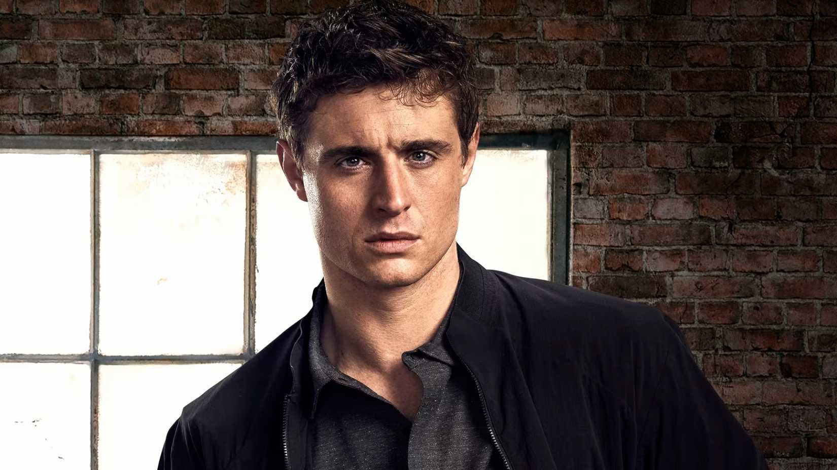 Joe stands by a brick wall in Condor