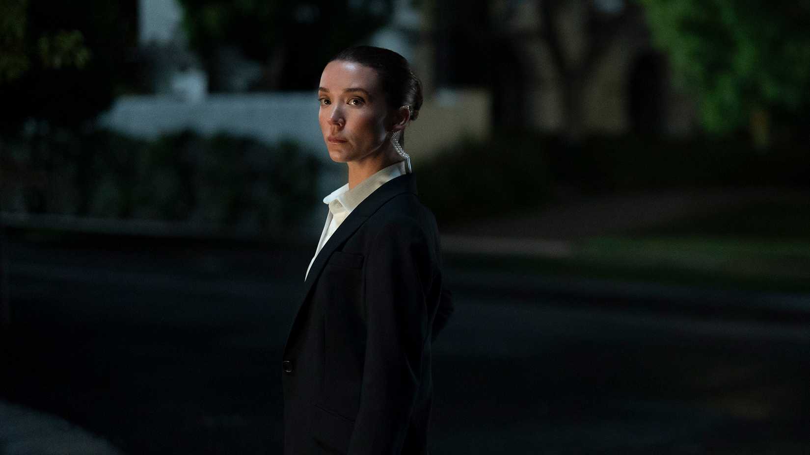 Jane standing outside in the dark in Paradise. 