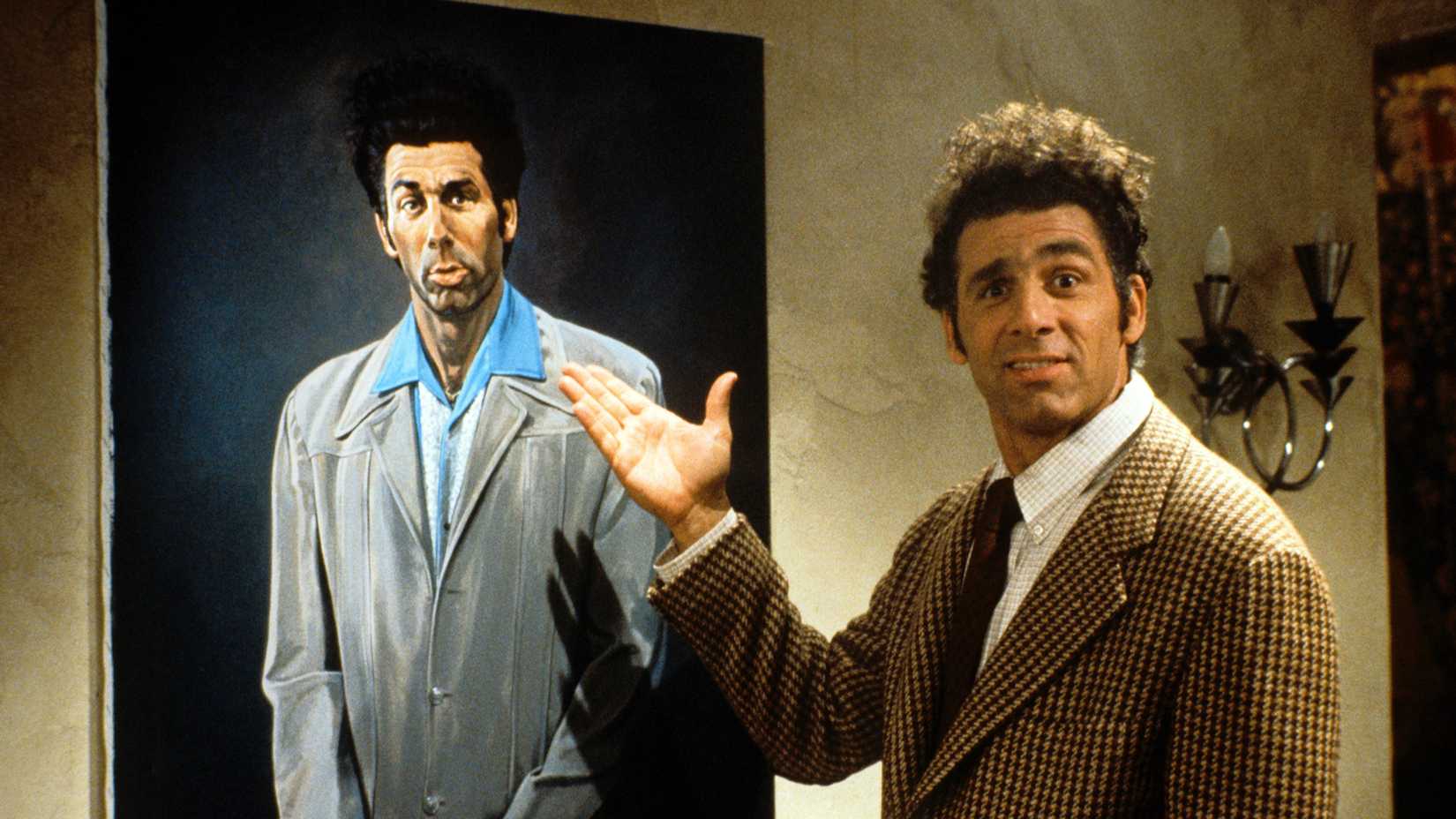 Kramer pulling a face as he points to a painting of himself in Seinfeld.