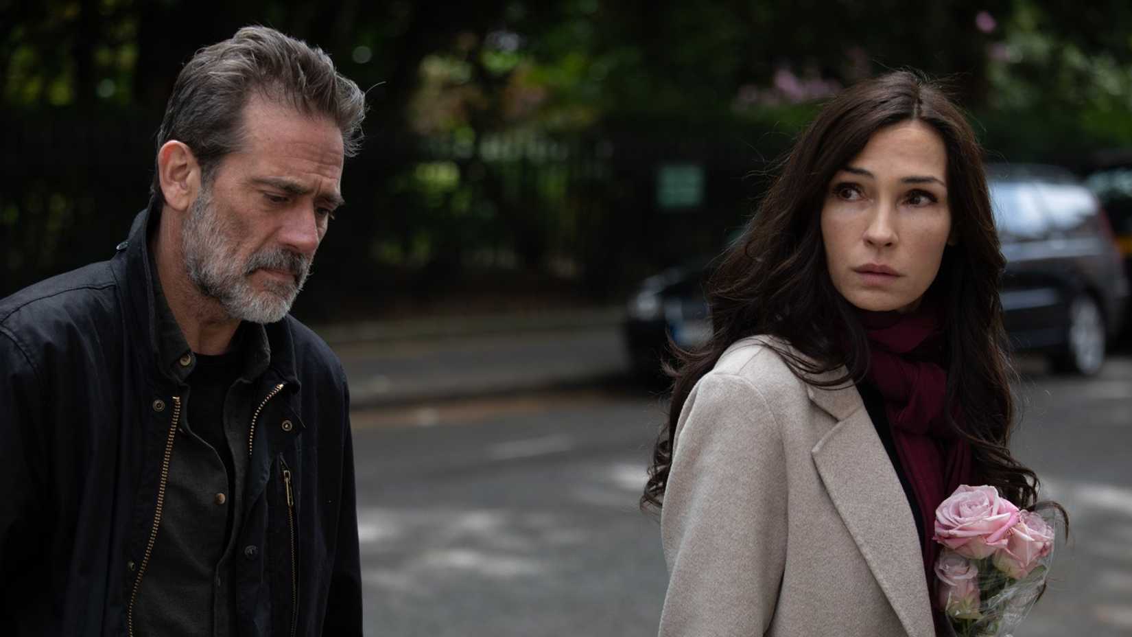 A man and woman walking and looking sad in The Postcard Killings.