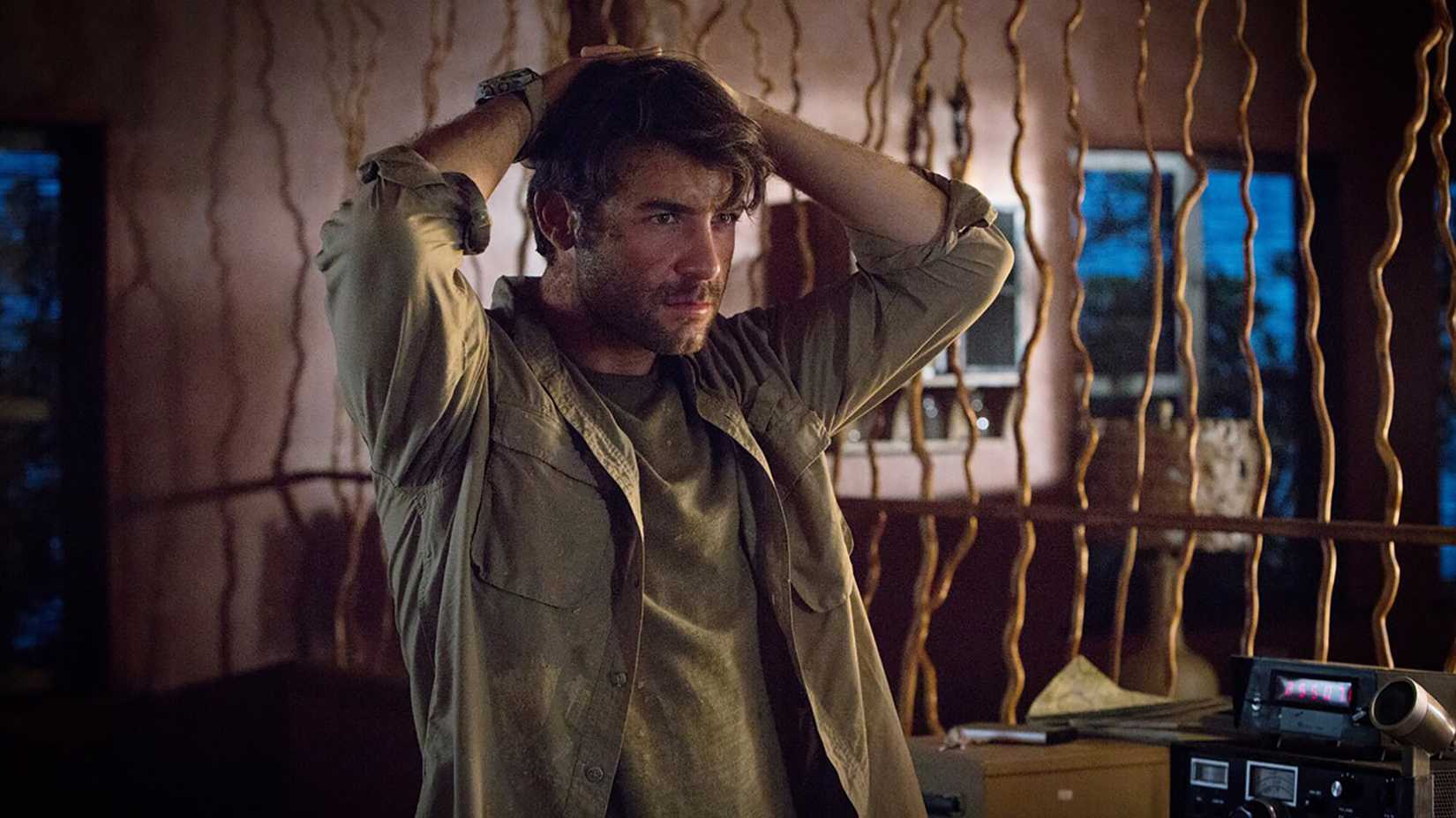 A young man with his hands held at the back of his head in Zoo.