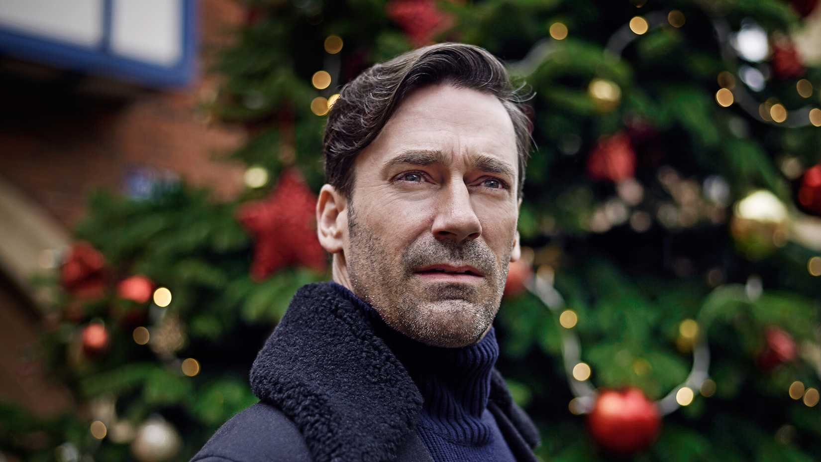 Jon Hamm as Matt standing in front of a Christmas tree and staring off in the Black Mirror episode "White Christmas."