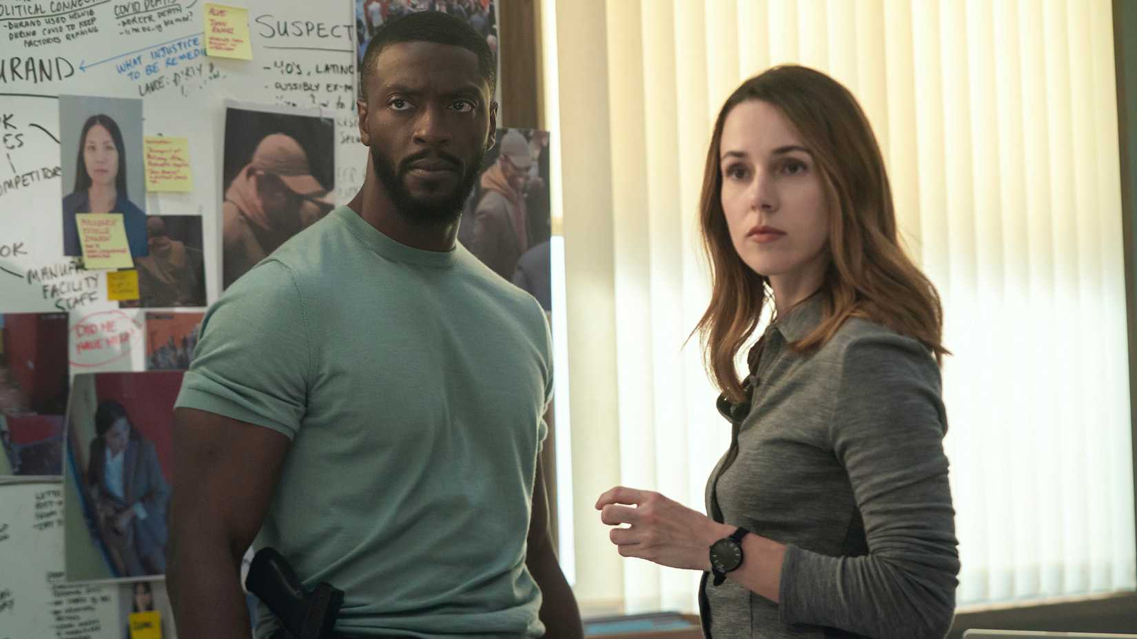 Alex and Kayla standing together looking at someone in Cross.