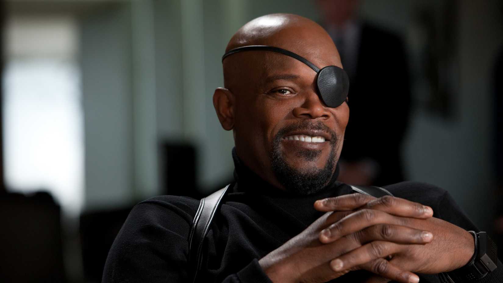 Samuel L. Jackson as Nick Fury smirking as he sits back in his chair and links his fingers in Iron Man 2.