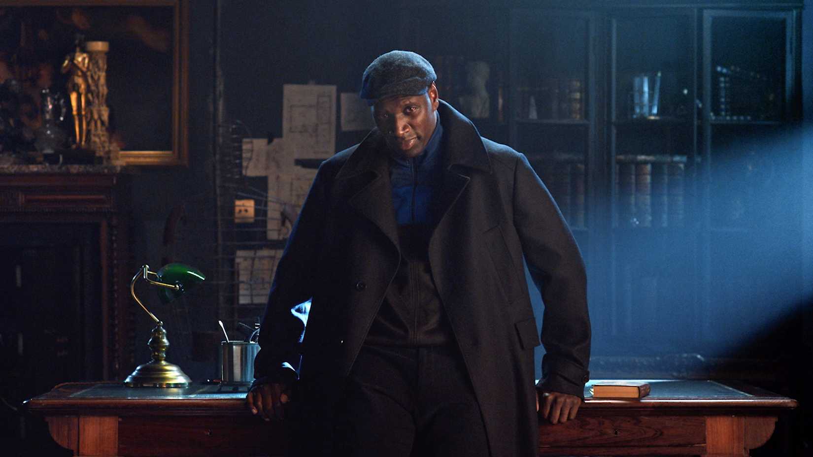 Lupin leaning against a desk looking menacing.