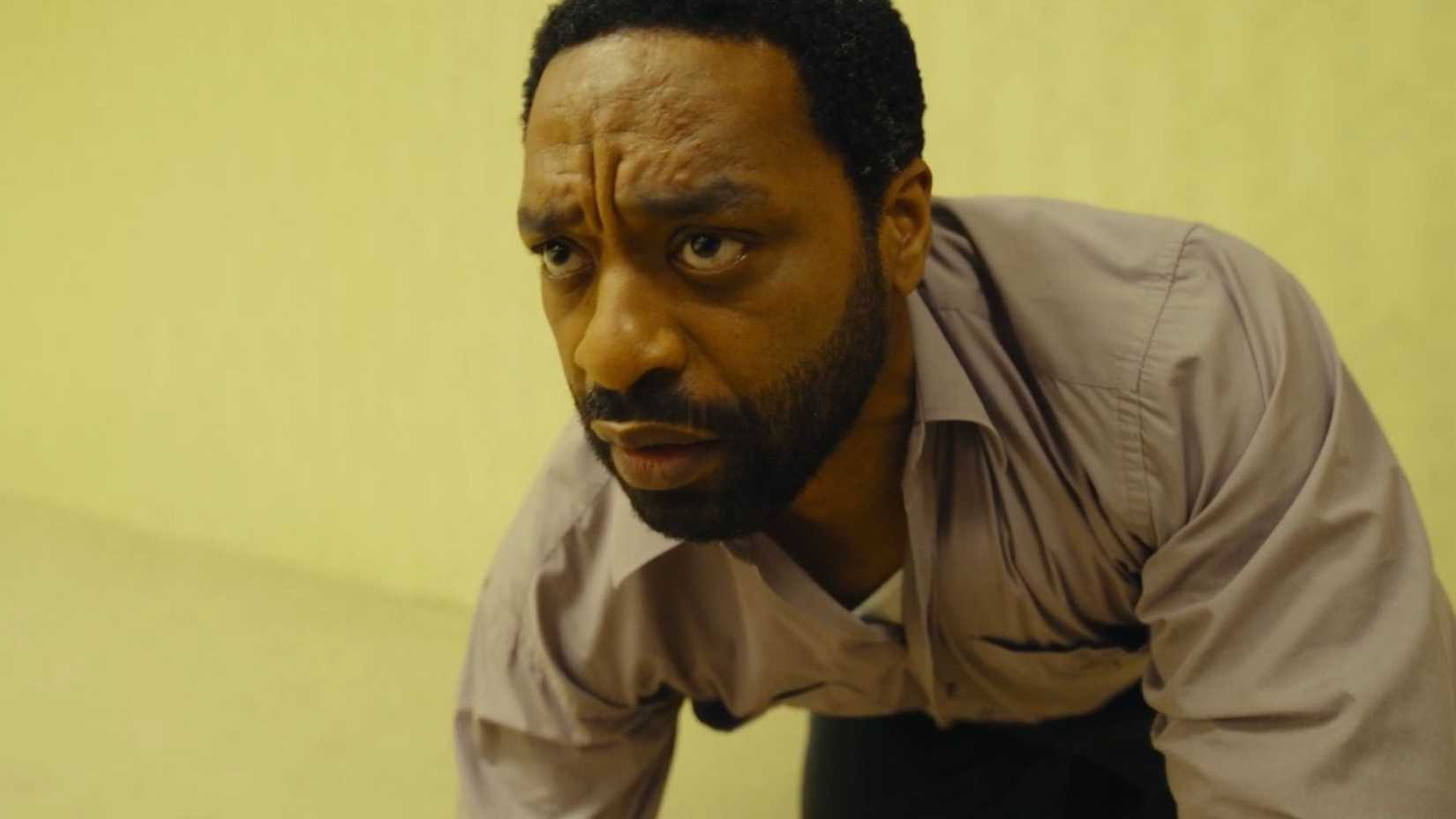 Chiwetel Ejiofor looking concerned as he crouches in Backrooms.