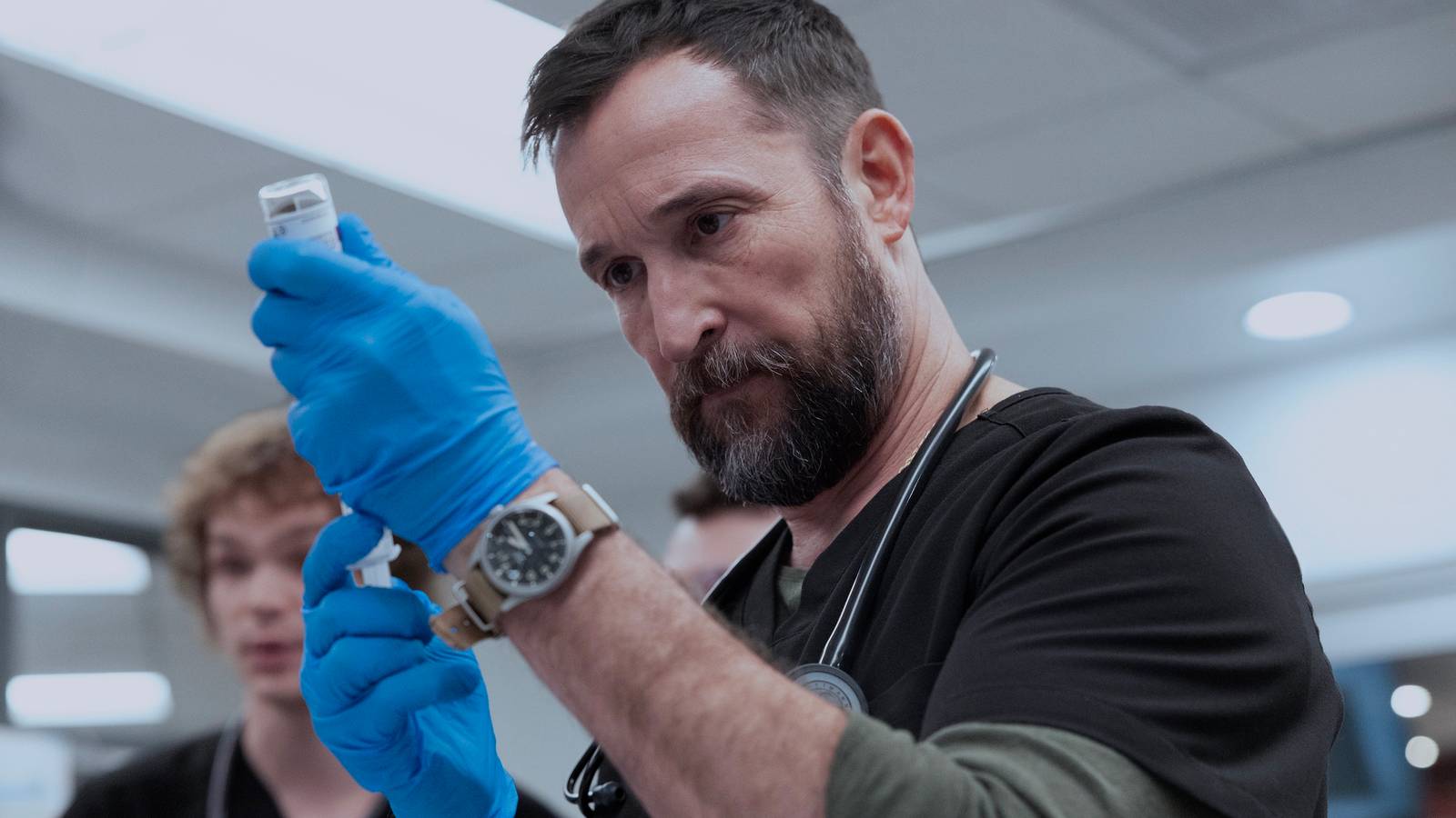 Robby wearing gloves and carefully filling a syringe in The Pitt.