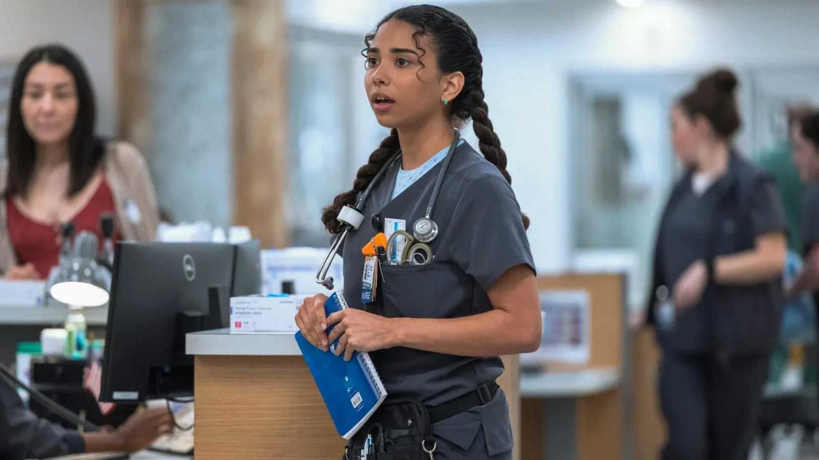 Nurse Emma holds a notebook in The Pitt