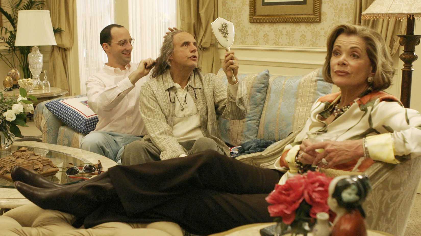 Buster brushing Oscar's hair in the penthouse as Lucille lies next to them in Arrested Development.
