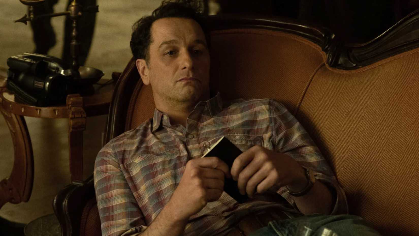 Matthew Rhys lies on a sofa in Widow's Bay