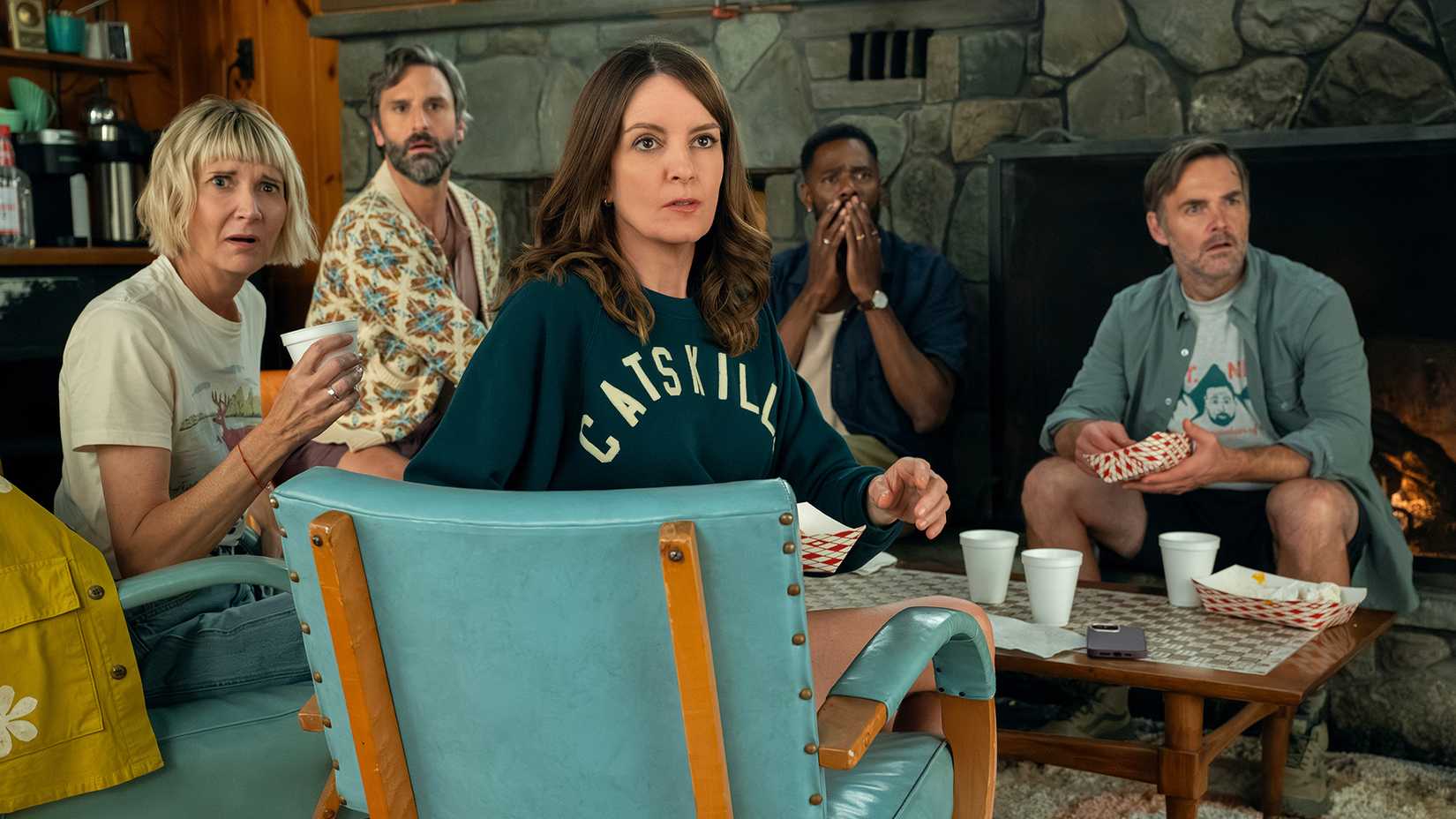The friends at a table looking back stunned in The Four Seasons.