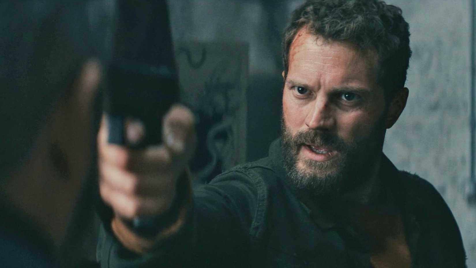 Elliot points a gun at a man in The Tourist