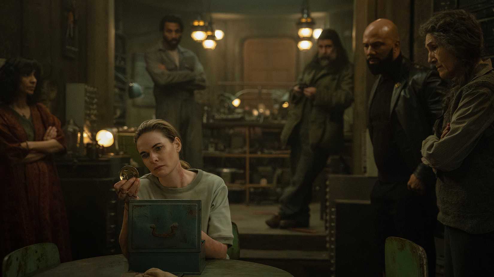 Jules looking at relics while others look on in Silo.