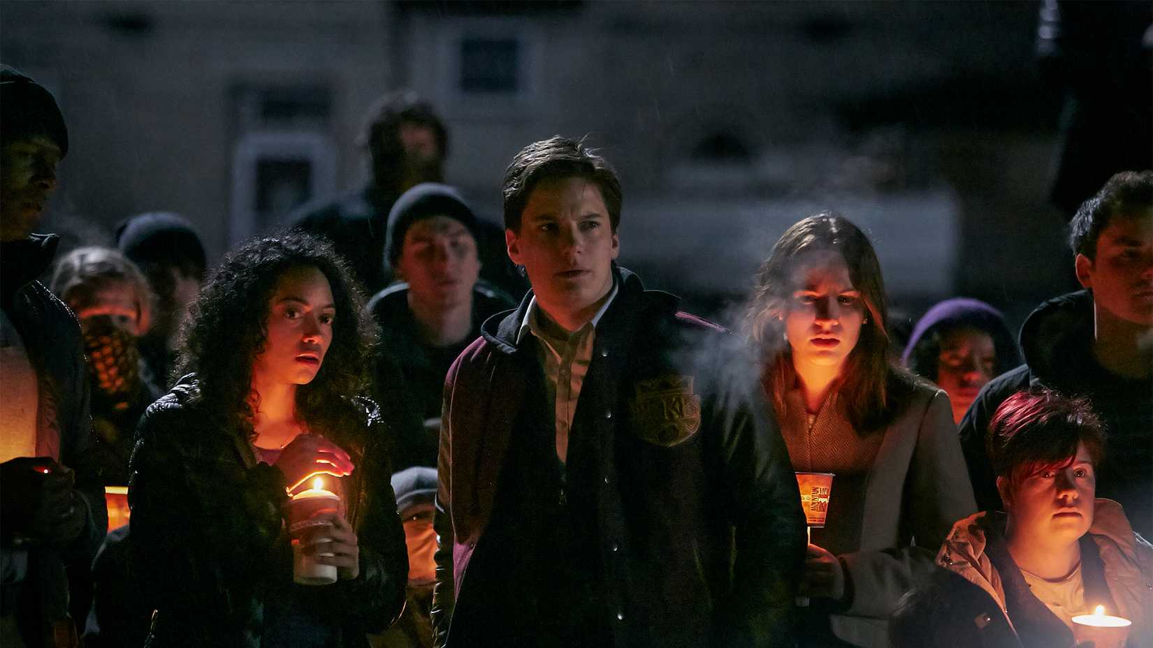 Young adults standing in the dark with lights in Between.