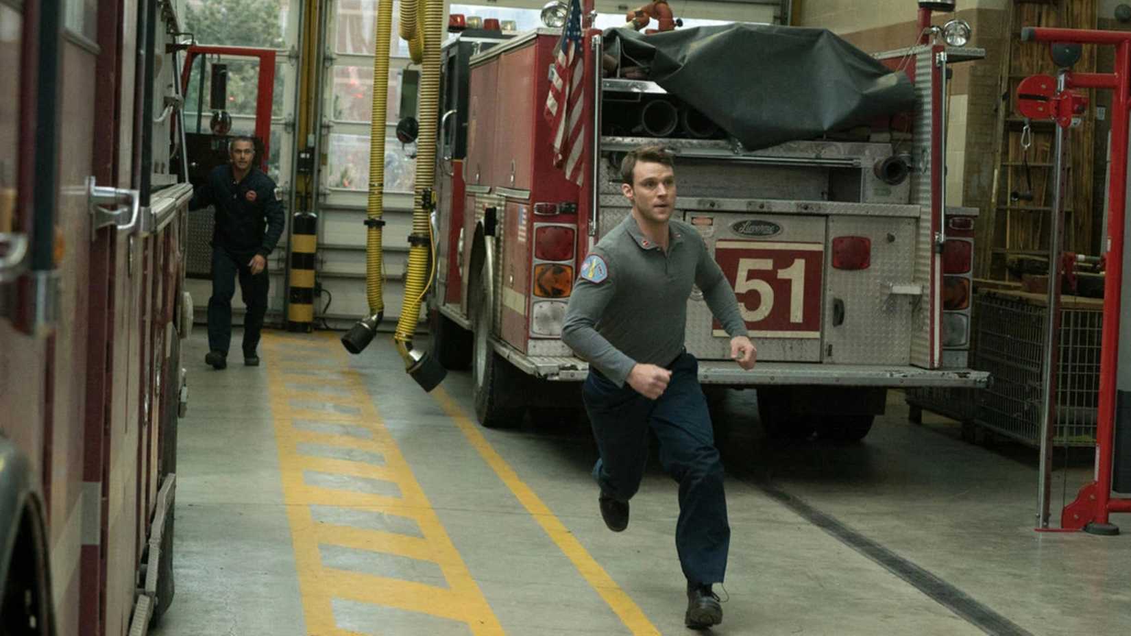 A man races by a firetruck in Chicago Fire