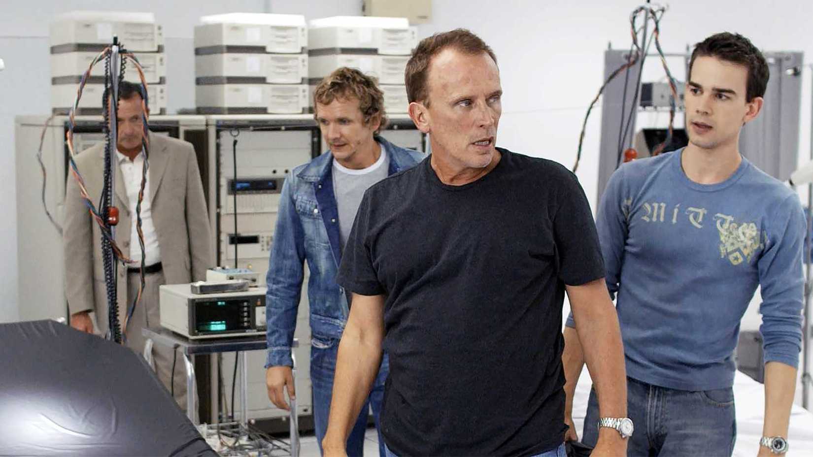 Several people in a lab in the show Odyssey 5.