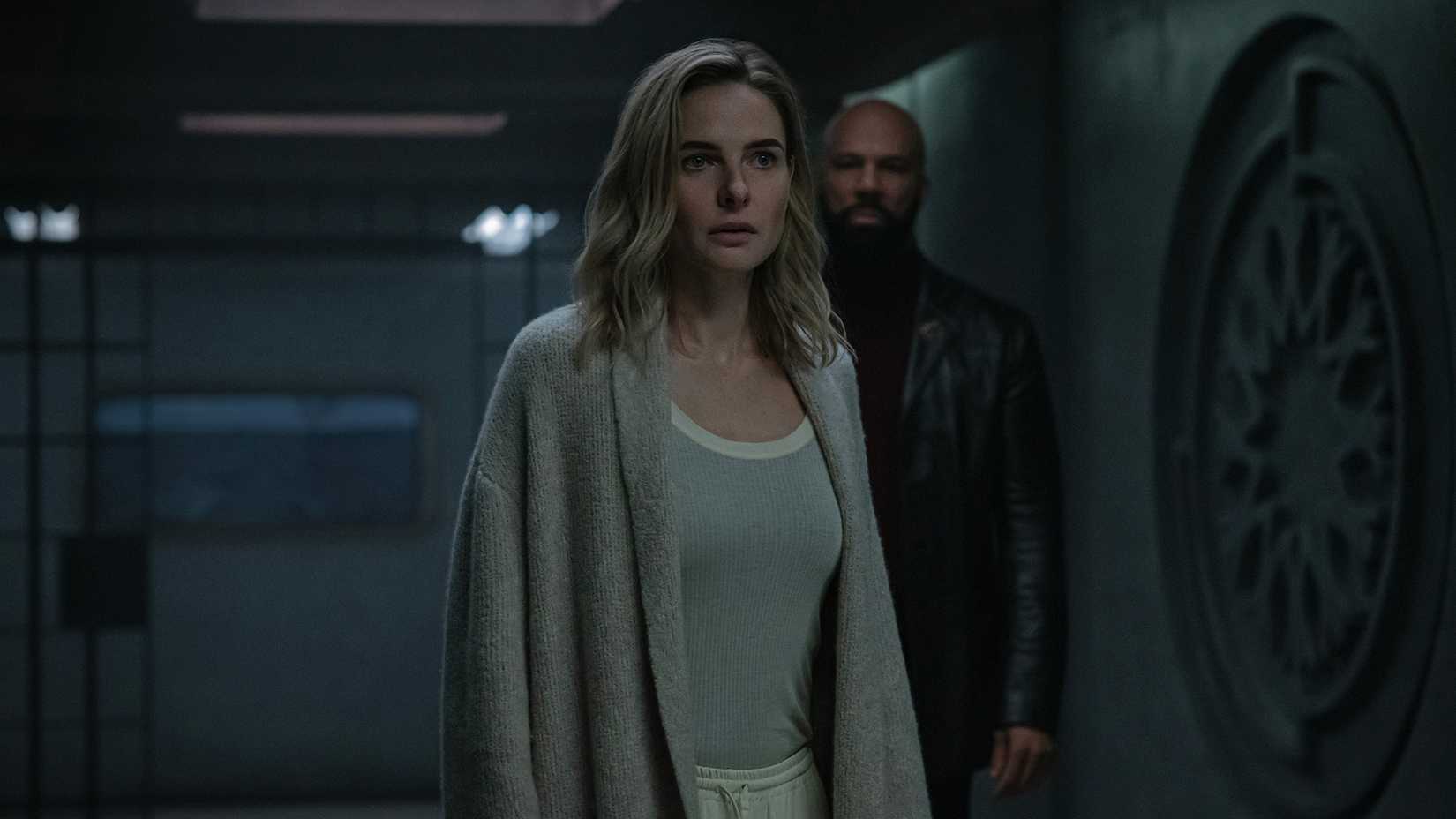 Jules standing in a hallway in a robe with Sims behind her in Silo.
