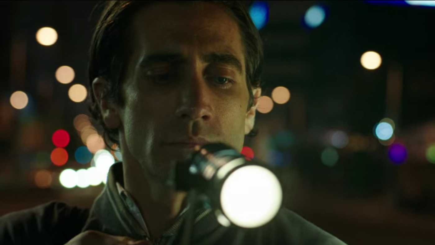 Jake Gyllenhaal as Lou Bloom pointing a video camera in Nightcrawler