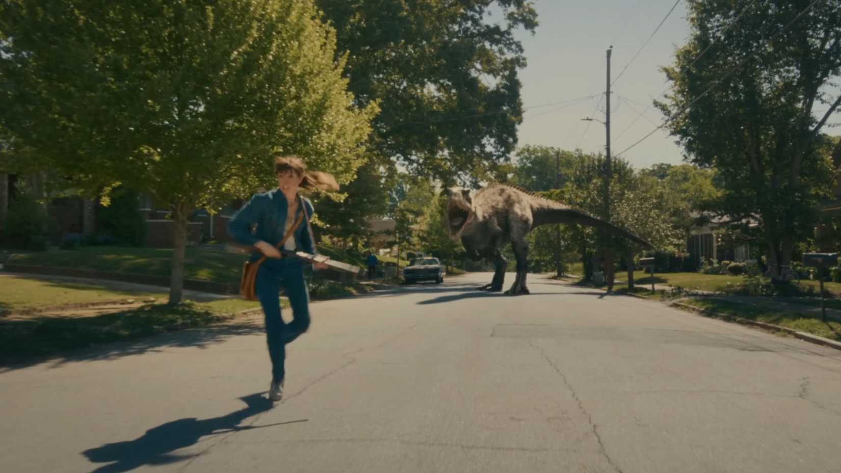 Anne Hathaway as Denise Platt running away from a dinosaur in The End of Oak Street