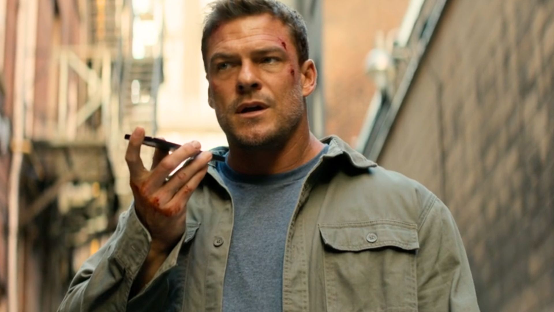 Alan Ritchson on the phone as Jack Reacher in Reacher