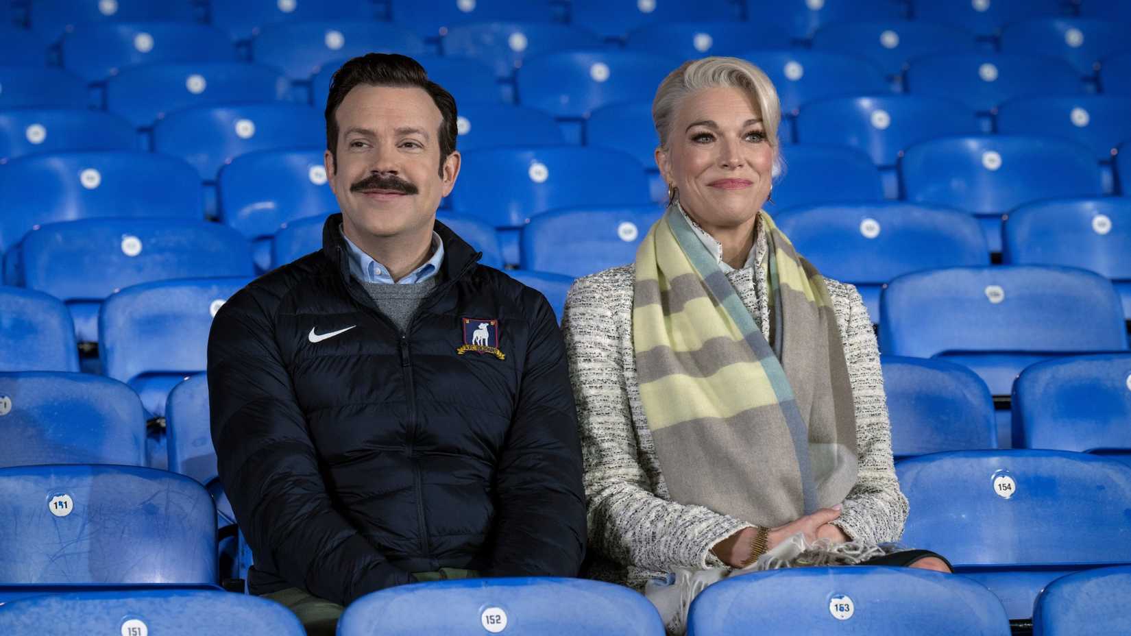 Ted and Rebecca sitting together in Richmond's football ground stands in Ted Lasso.