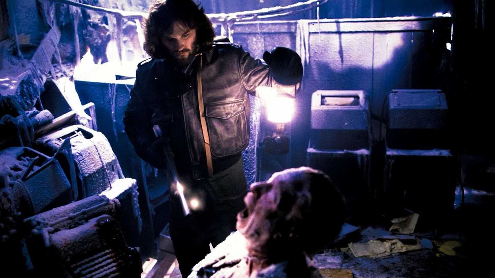 MacReady shines light on a corpse in The Thing