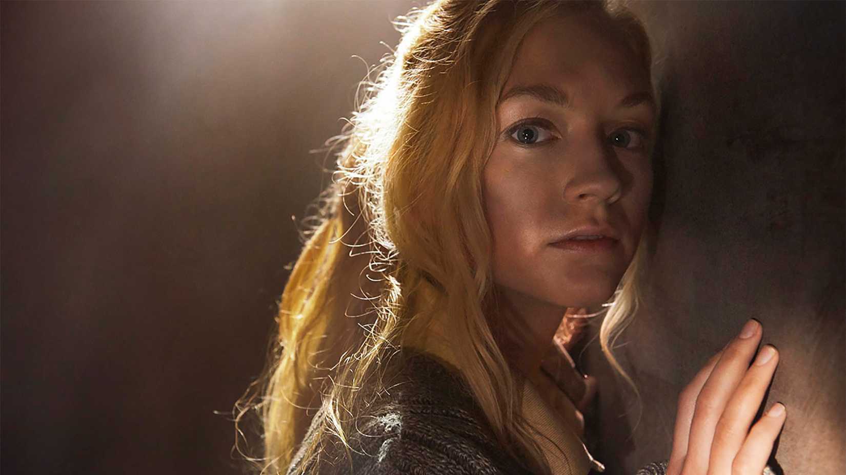 Beth in the dark with light on her leaning against a wall in The Walking Dead.