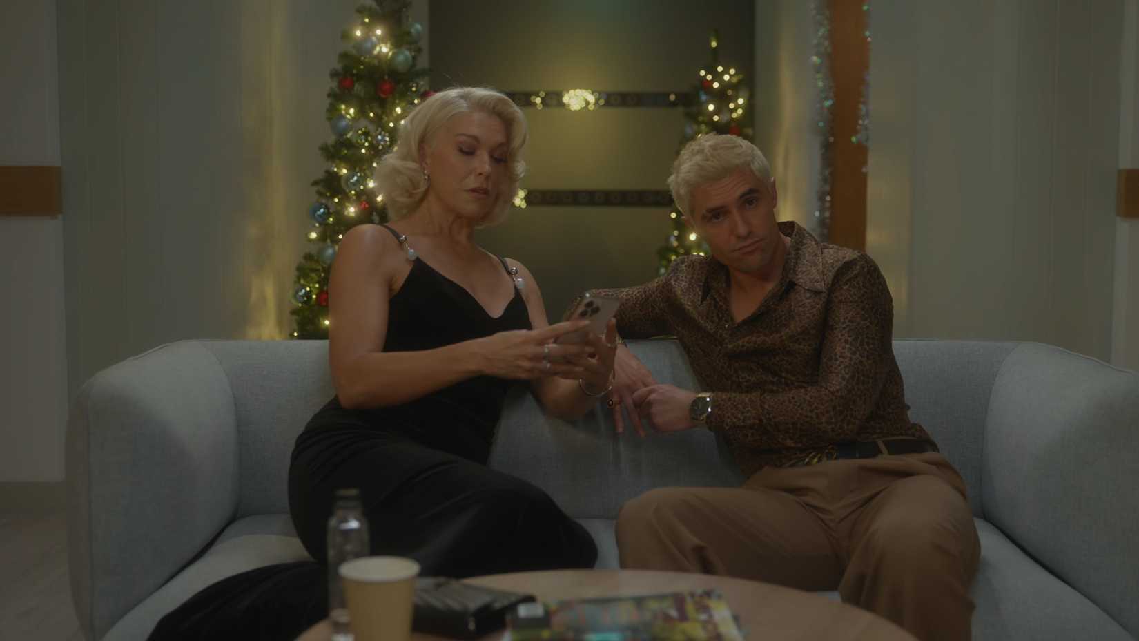 Rebecca looking at her phone, with Jamie sitting next to her, in the hospital waiting room in Ted Lasso.