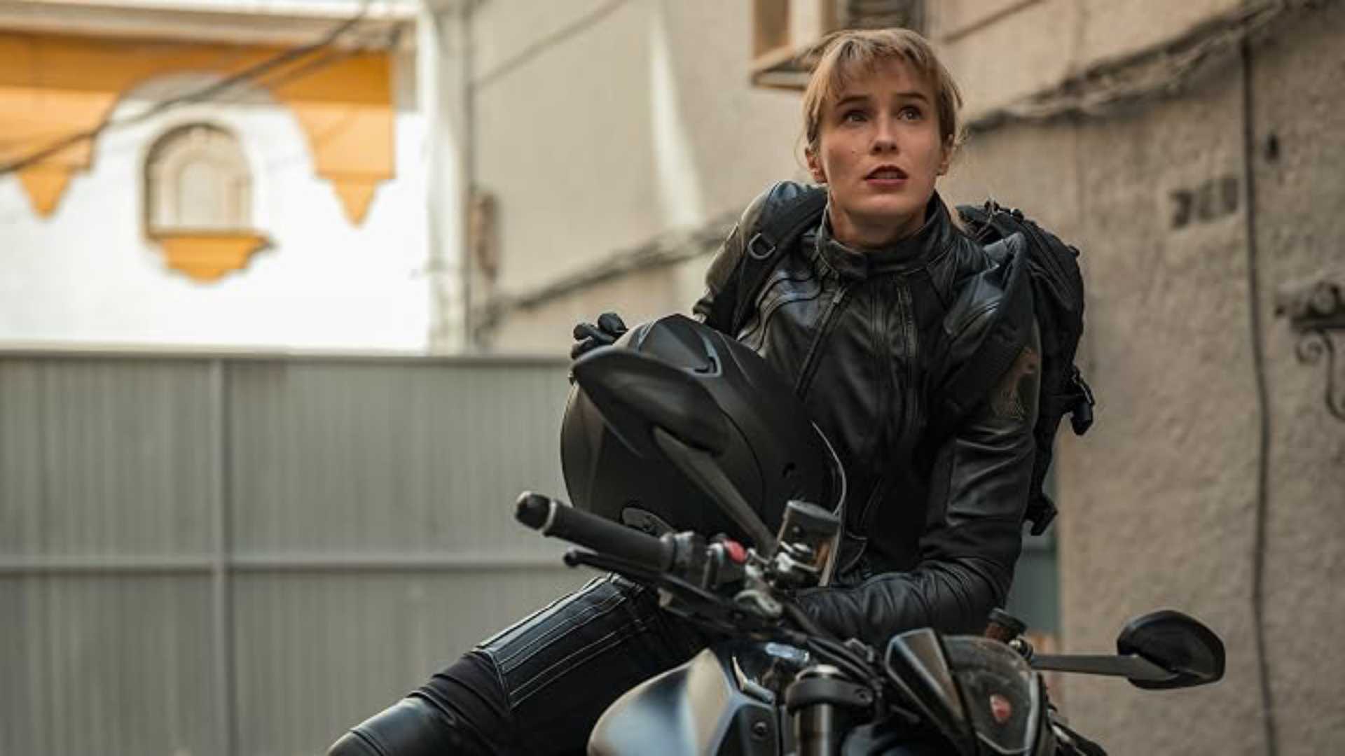 A woman gets on a bike in Red Queen