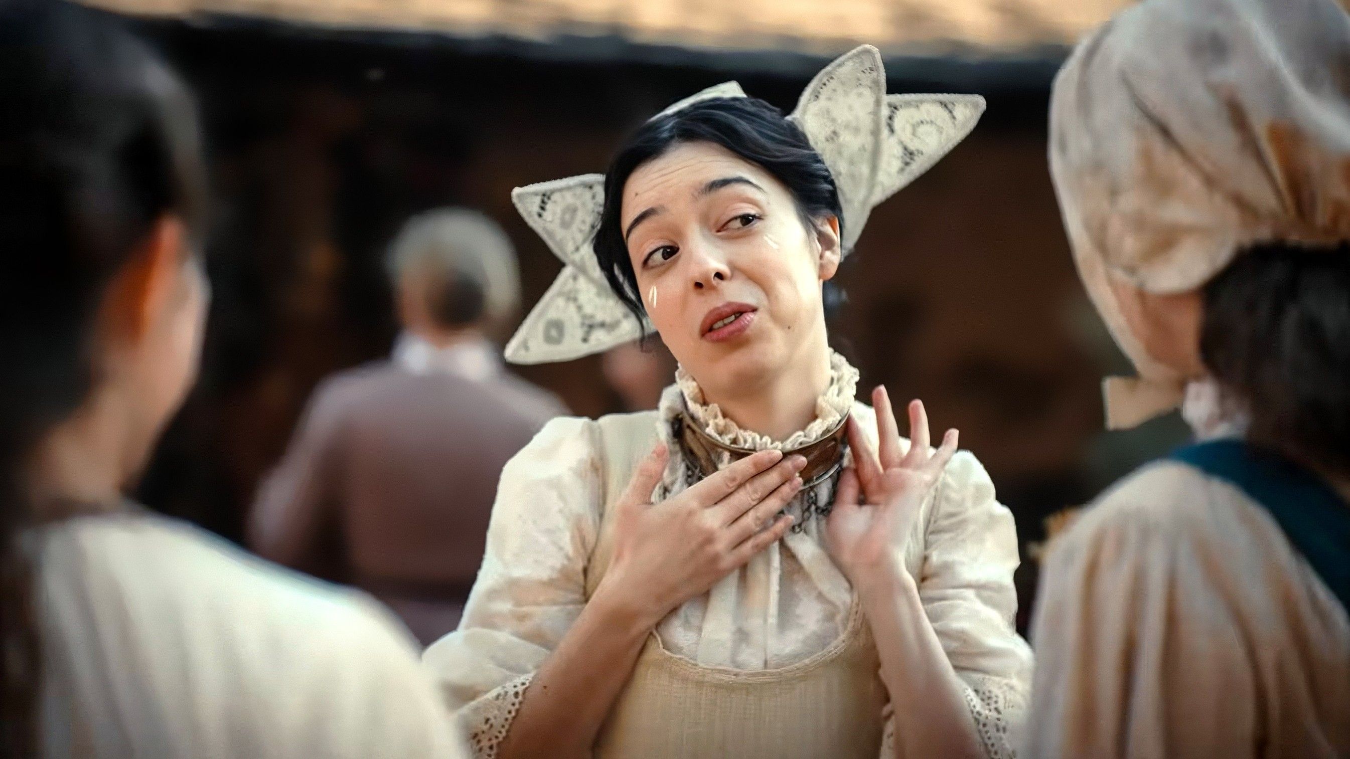 Marli Siu as the Tailor's Wife's sister showing off her marital collar in Wicker